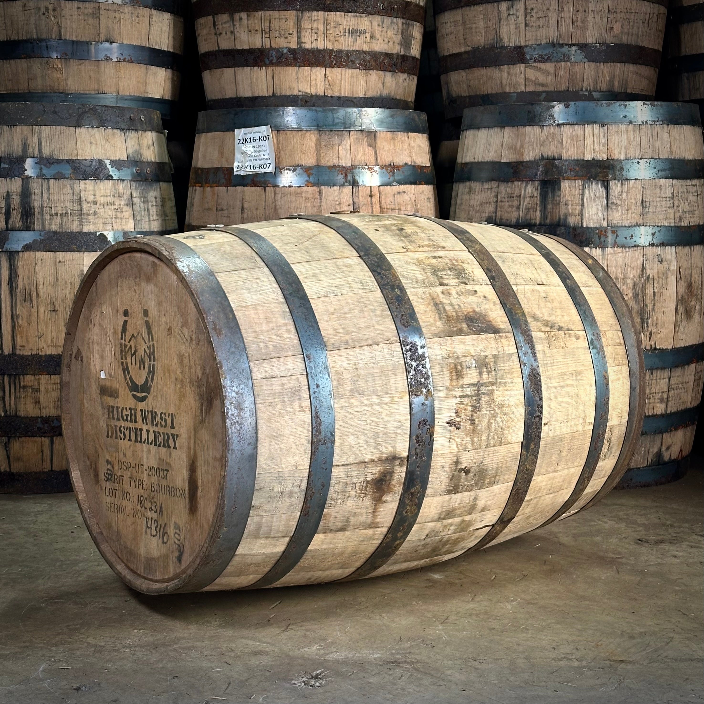 Wooden barrels with visible High West Distillery branding in a warehouse setting
