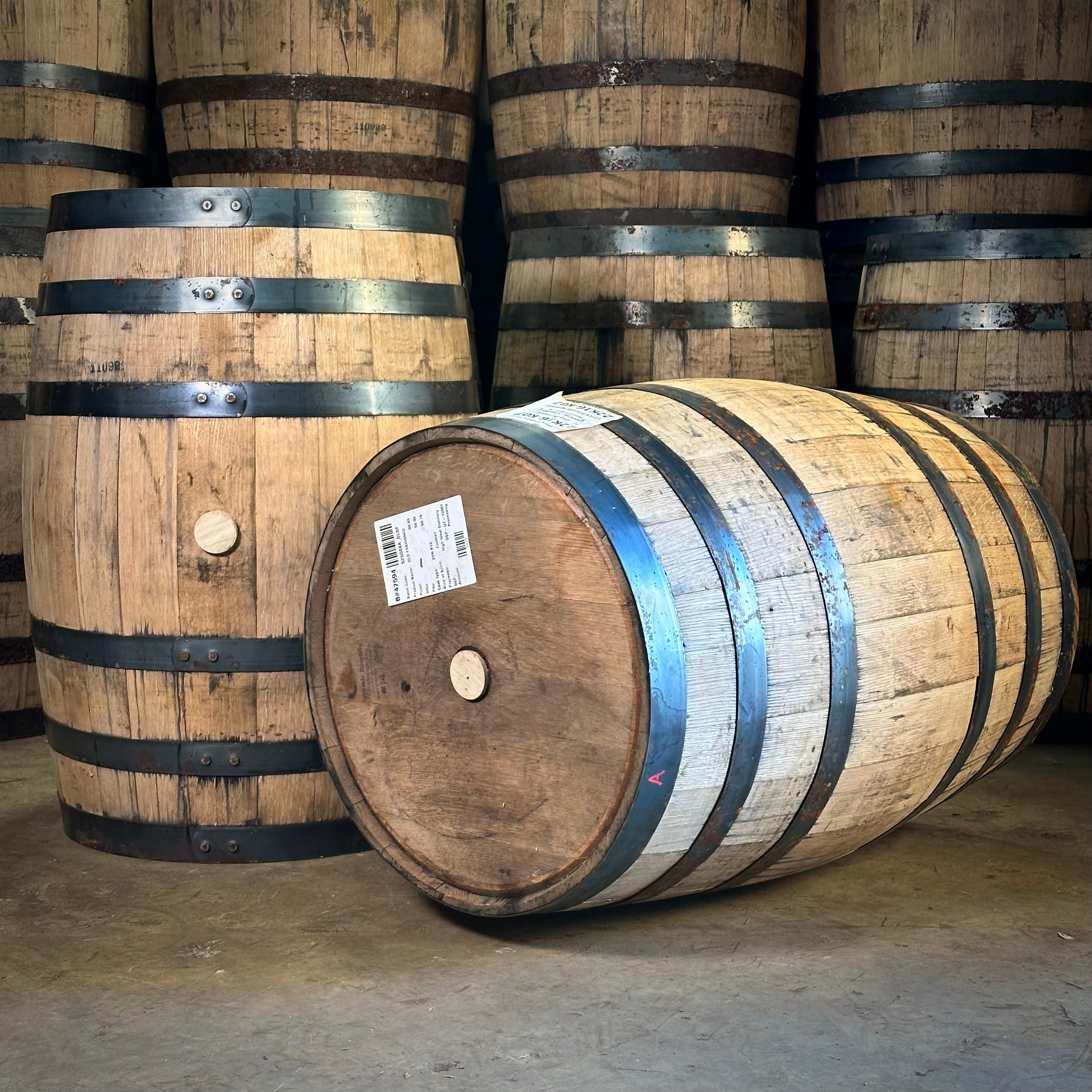 Wooden barrels with black bands on a concrete floor