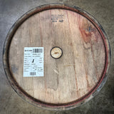 Wooden barrel with a label on a concrete floor