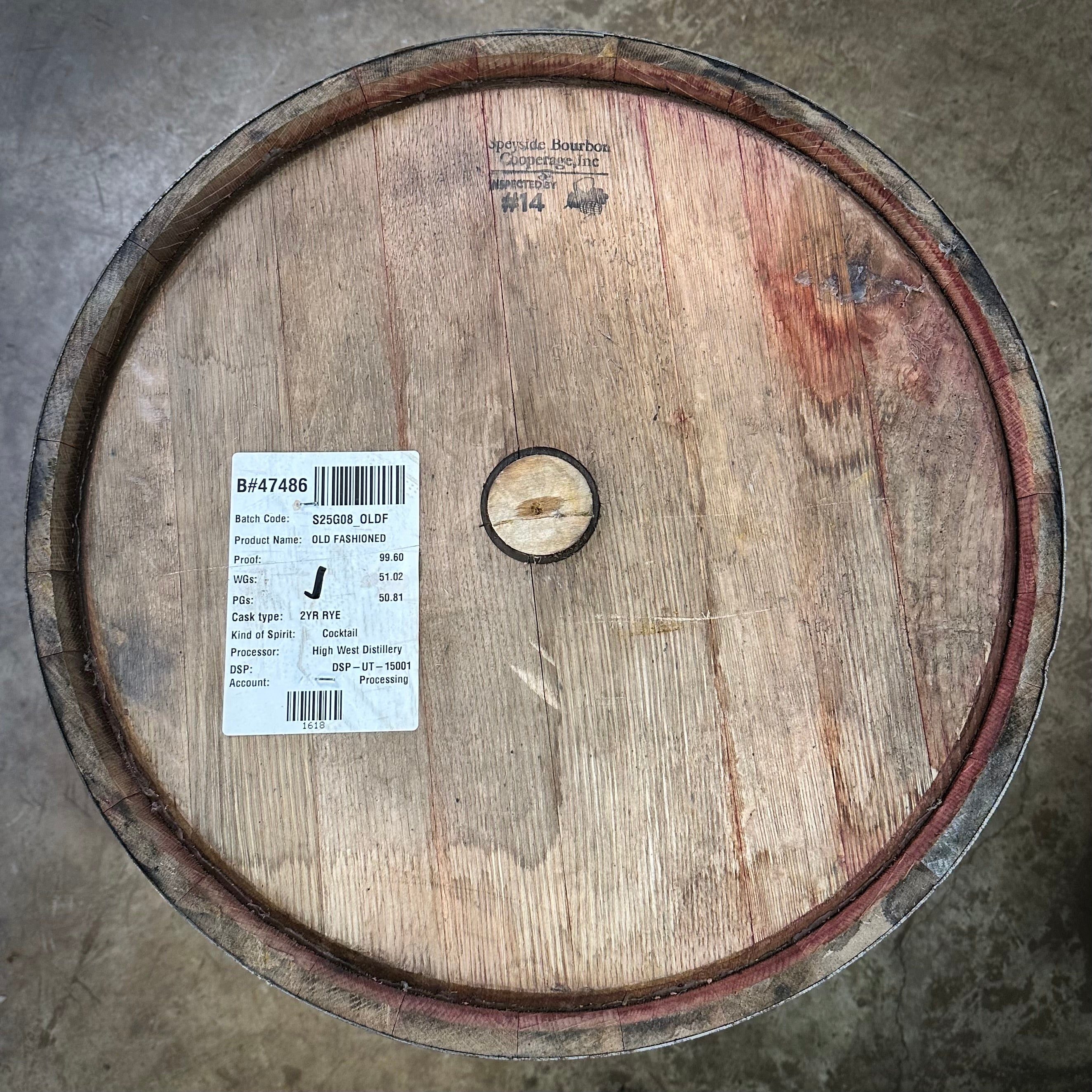 Wooden barrel with a label on a concrete floor