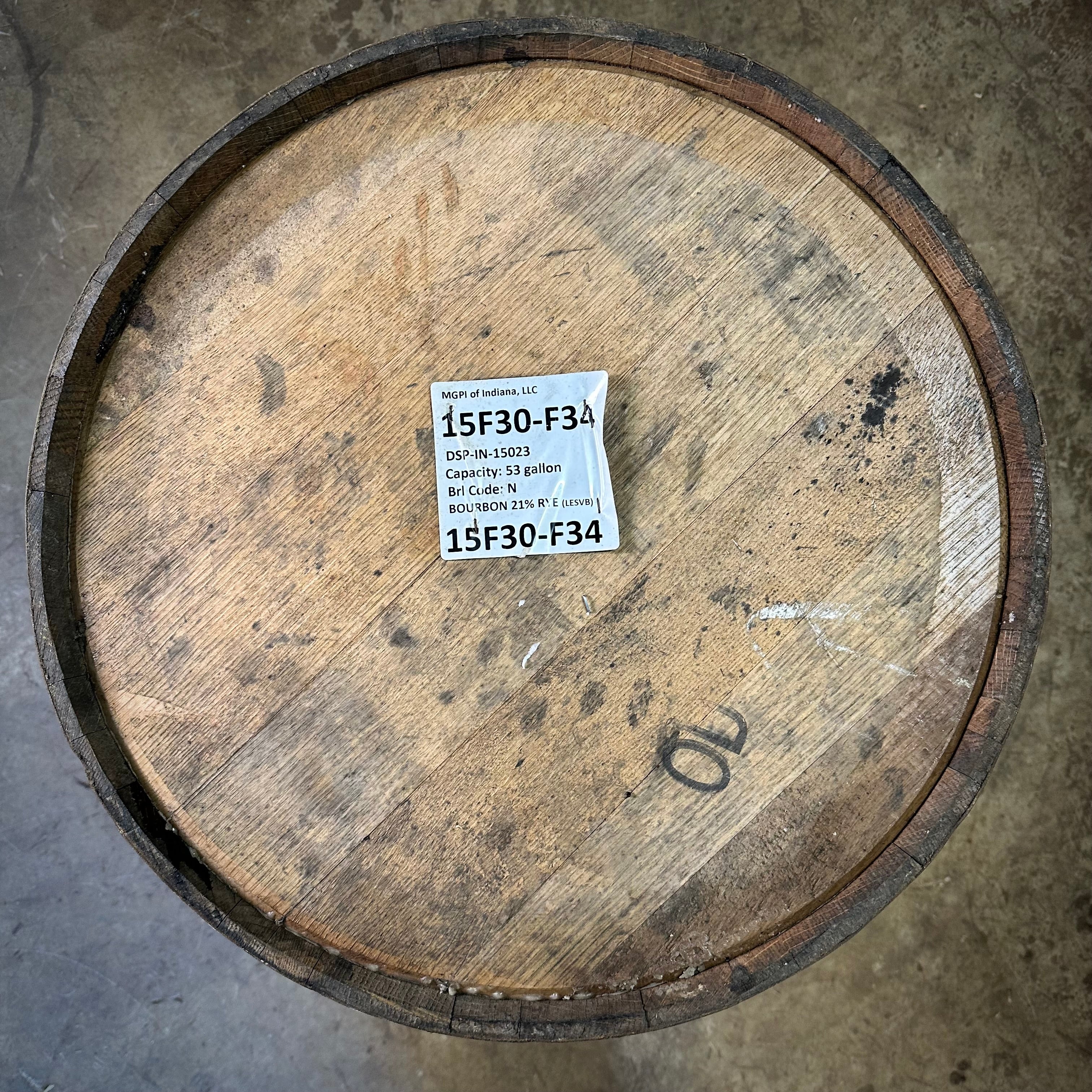 Wooden  rye bourbon barrel with a label on a concrete floor