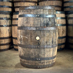 Stack of wooden barrels with metal bands on a wooden floor