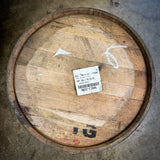 Wooden barrel with a label on a concrete floor